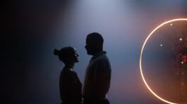 Theater Stage design. Two people close to each other in front of a glowing circle 